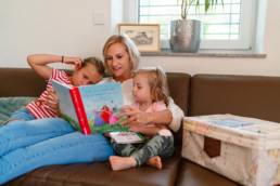 Mama liest Kindern ein Buch der Swirlcle Box vor.
